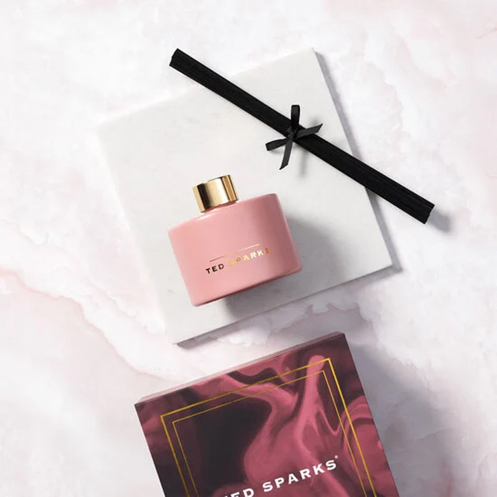 Roze geurstokjes van Ted Sparks in de geur Cypress en caramom, verpakt in een luxe cadeaudoos. 
